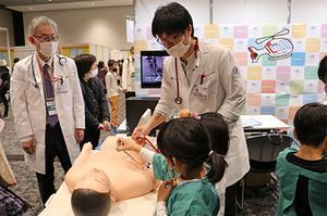 Person wearing a lab coat and listening to heart sounds with a stethoscope